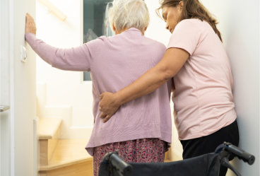 Woman Helping Elderly woman on Stairs at Home