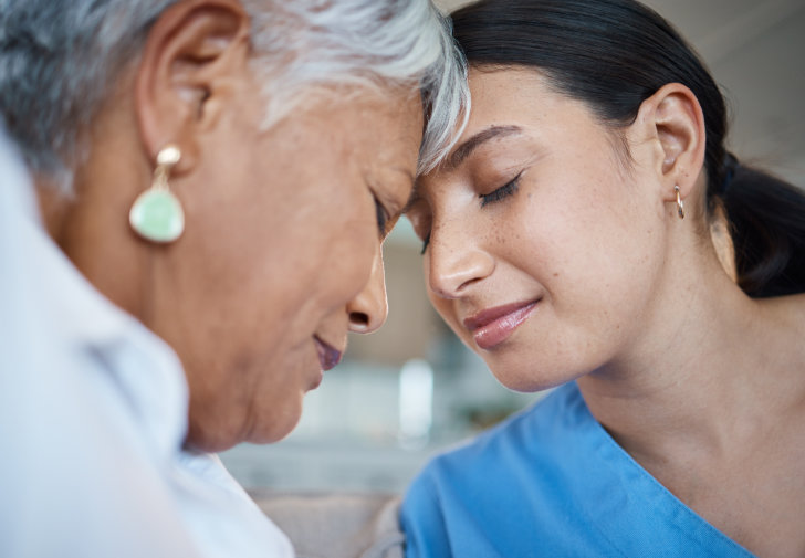 a caretaker and an elder comforting each other